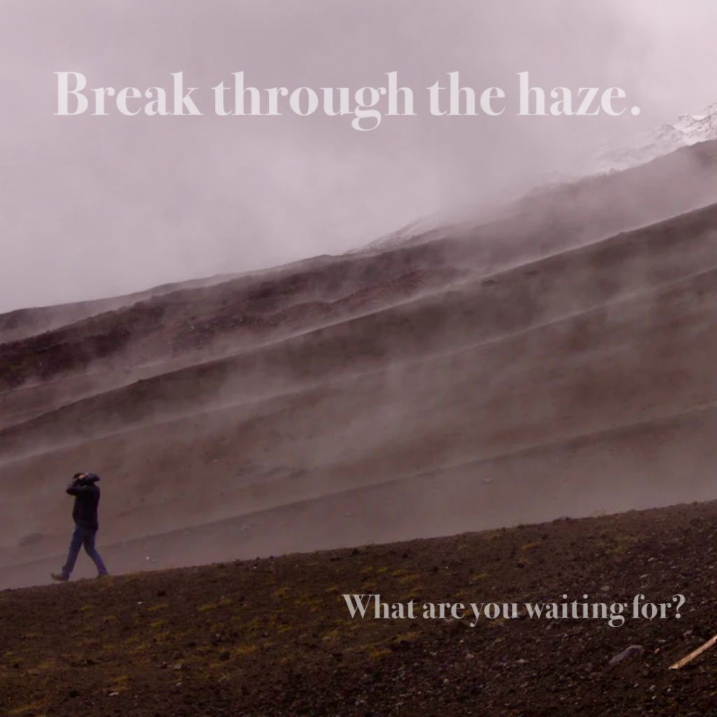 Man walking through the haze while covering his head with his coat