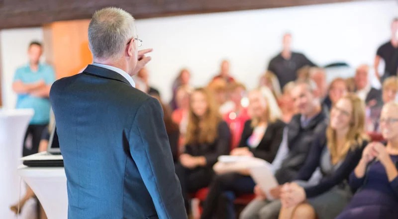 Speaker presenting to an engaged audience in conference.