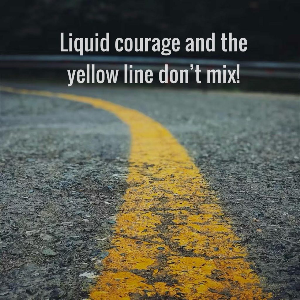 Curved yellow road line warning against drunk driving.