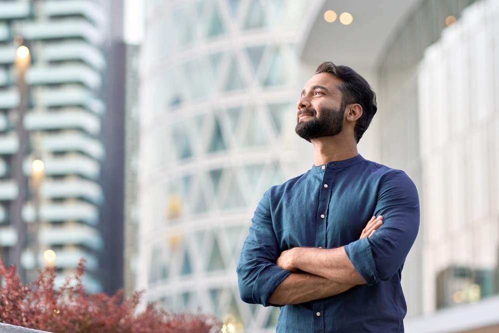 Man smiling confidently in urban setting