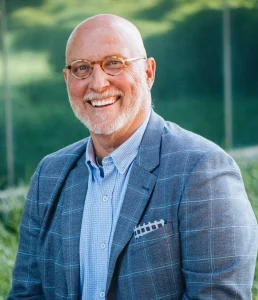 Smiling man in glasses and suit outdoors