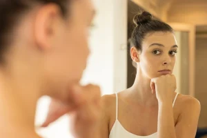 Woman with bun looking in mirror